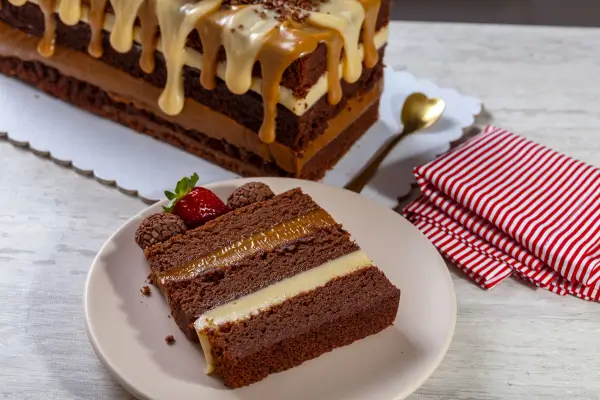 fatia de bolo de chocolate e morangocom brigadeiros e morangos