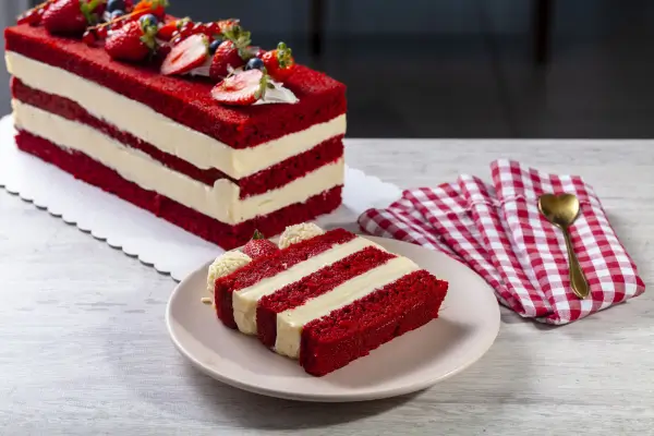 fatia de bolo de red velvet com dois recheios e morangos em cima